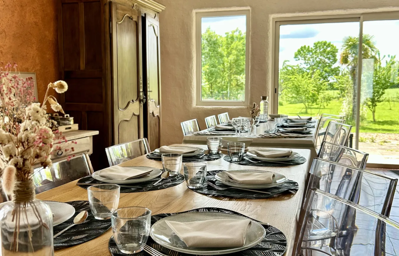 Salle à manger conviviale de la Villa des Jardins, grande table dressée face au jardin