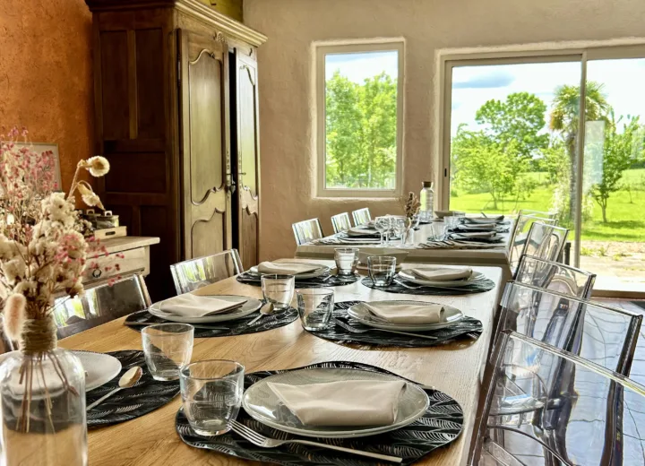 Salle à manger conviviale de la Villa des Jardins, grande table dressée face au jardin